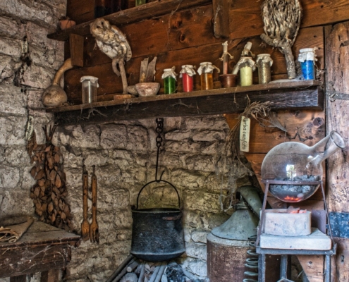 Old kitchen with stove and bottles of herbs on shelves