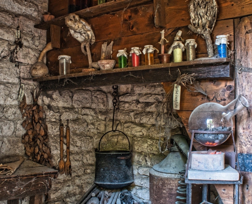 Old kitchen with stove and bottles of herbs on shelves